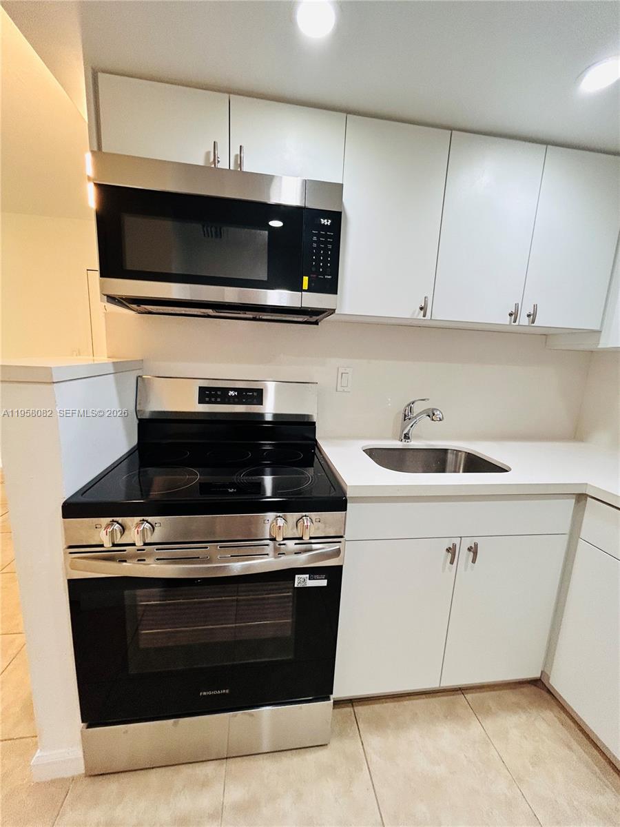 8603 Southwest 68th Court, Unit 22 Miami, FL 33156 - Photo 10 of 49 a stove top oven sitting inside of a kitchen