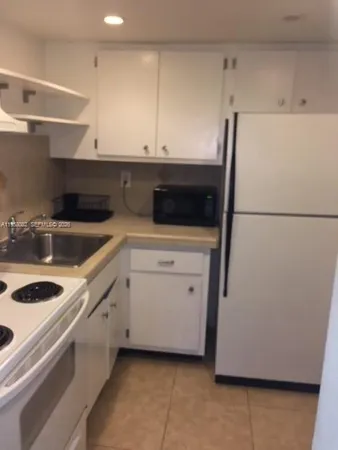 a kitchen with a sink and white cabinets