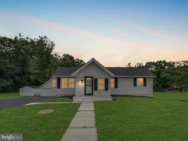 a front view of a house with a garden and yard