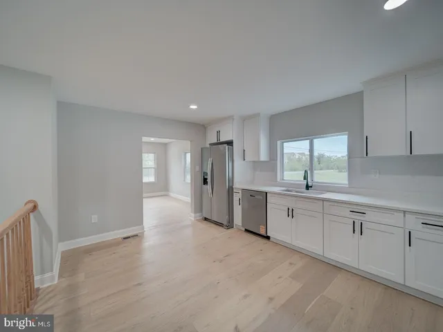 a view of an empty room with wooden floor and entryway