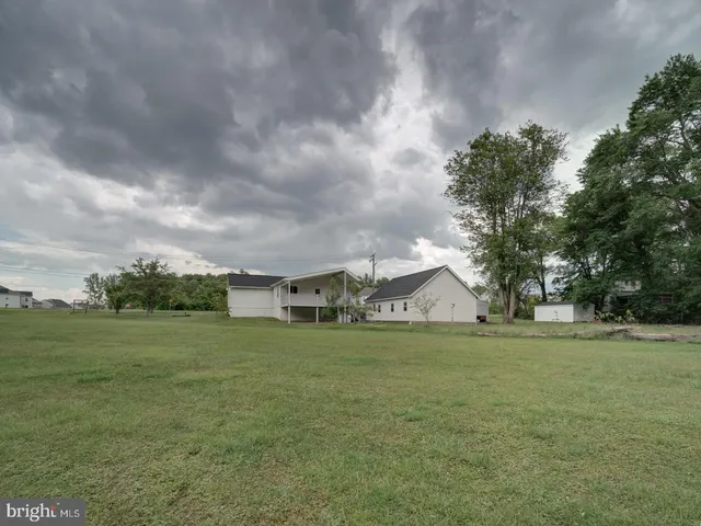 a view of a big room with a big yard and large trees