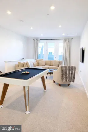 a living room with furniture a flat screen tv and a table