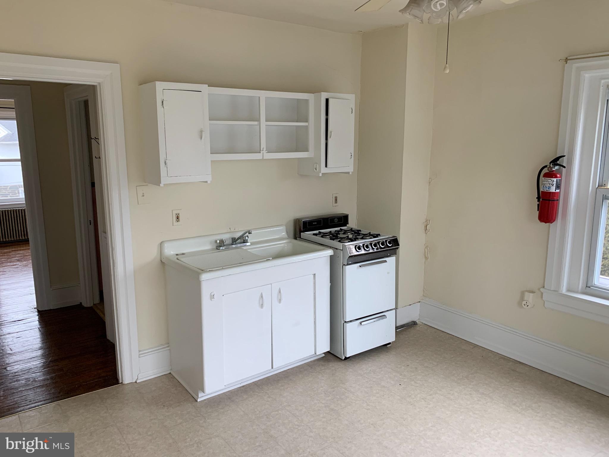 800 Darby Road, Unit 2A Havertown, PA 19083 - Photo 3 of 8 a kitchen with white cabinets and black appliances