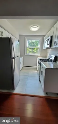 a view of a kitchen with wooden floor and electronic appliances