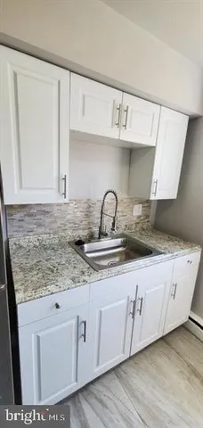 a kitchen with granite countertop a sink and cabinets