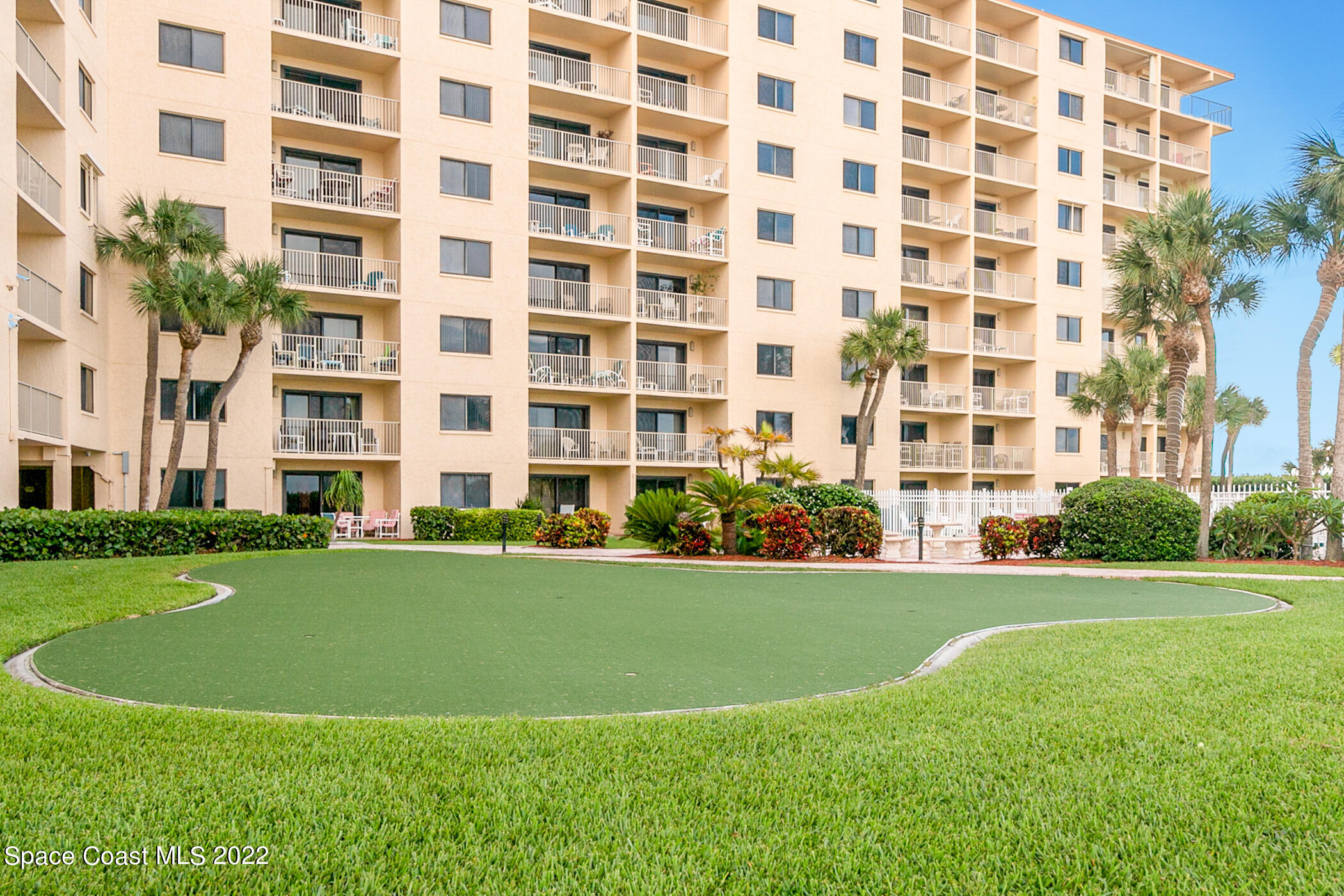 7520 Ridgewood Avenue, Unit 104 Cape Canaveral, FL 32920 - Photo 18 of 35 a view of a building with a yard