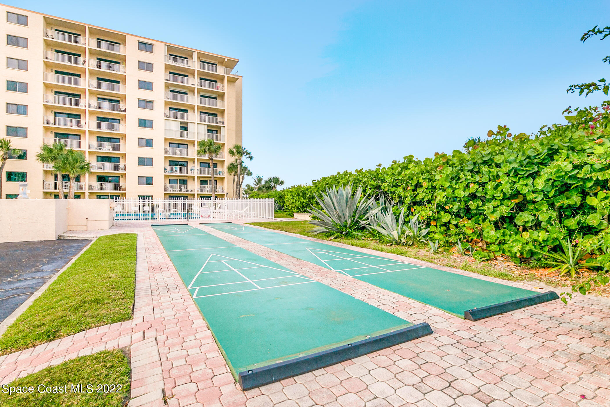 7520 Ridgewood Avenue, Unit 104 Cape Canaveral, FL 32920 - Photo 21 of 35 a view of a swimming pool with a garden and plants