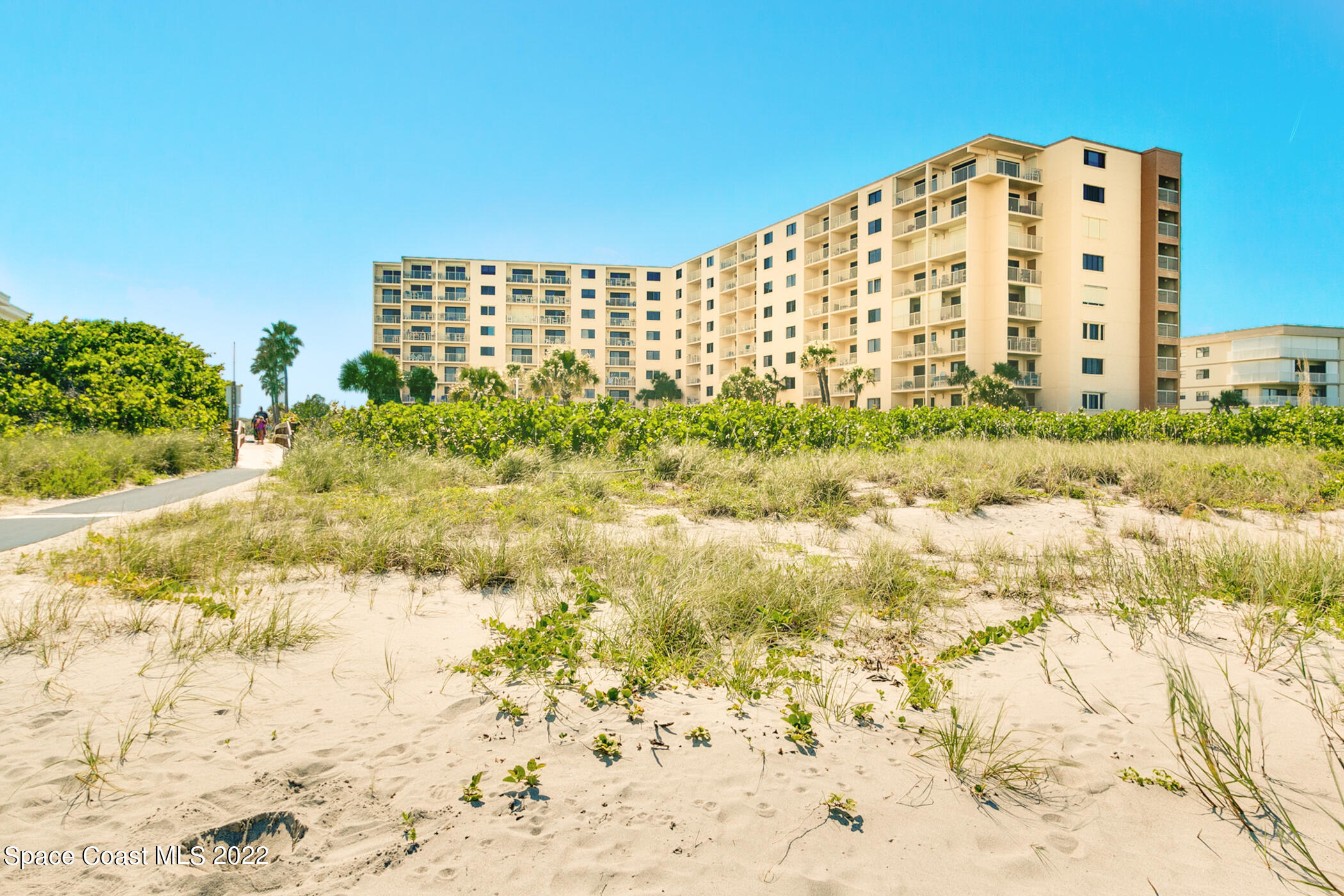 7520 Ridgewood Avenue, Unit 104 Cape Canaveral, FL 32920 - Photo 26 of 35 a view of a large building with a yard