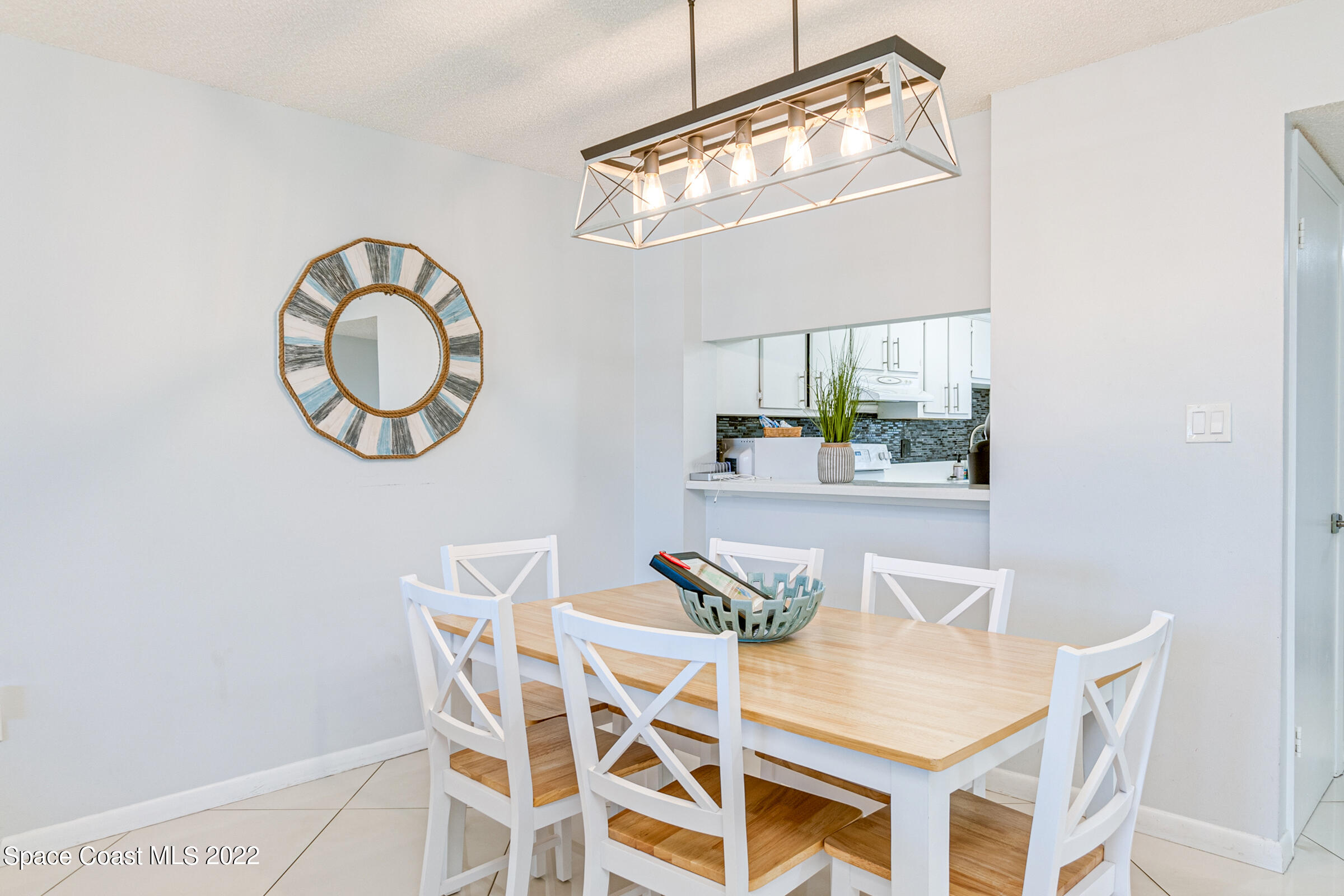 7520 Ridgewood Avenue, Unit 104 Cape Canaveral, FL 32920 - Photo 6 of 35 a view of a dining room with furniture and a chandelier