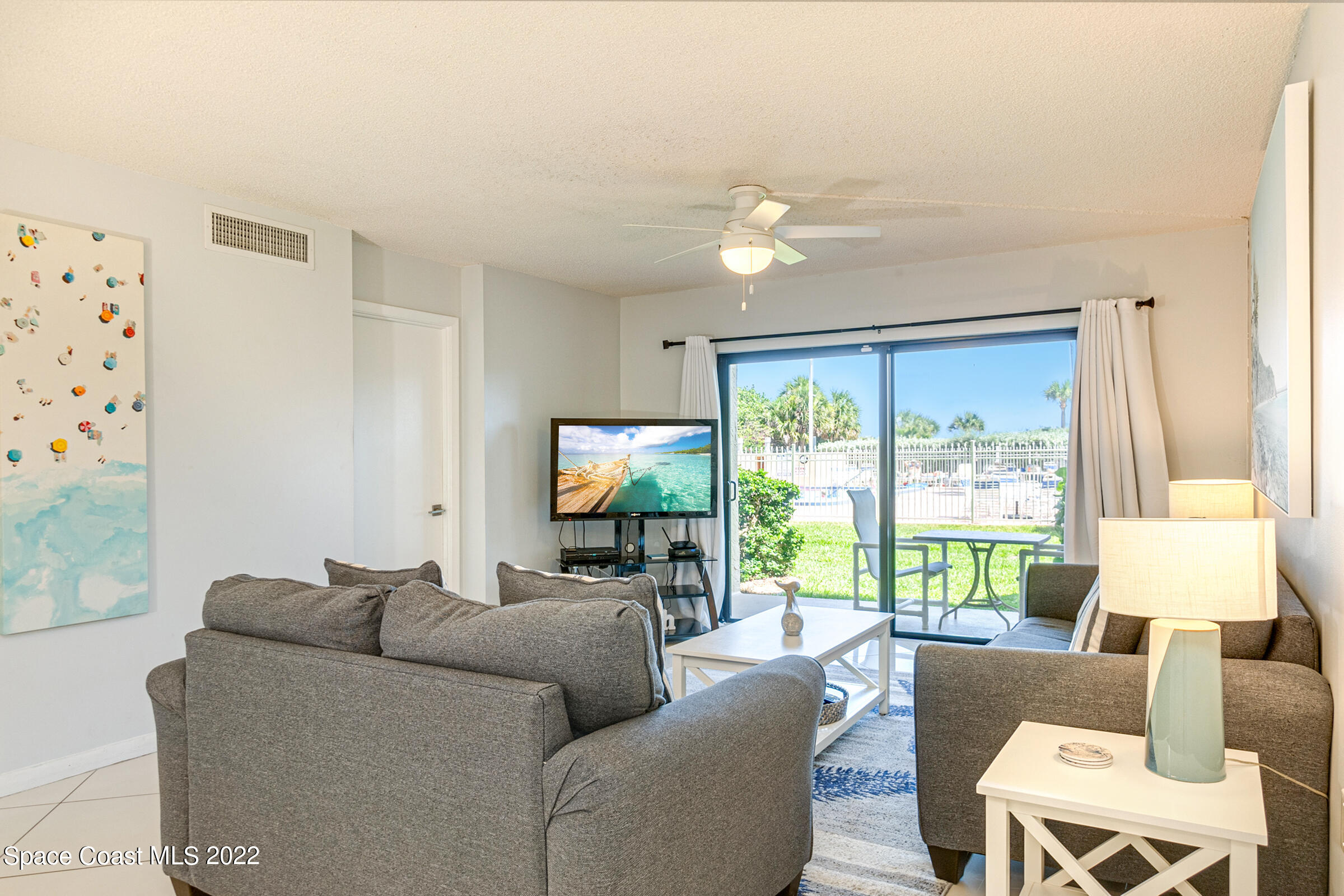 7520 Ridgewood Avenue, Unit 104 Cape Canaveral, FL 32920 - Photo 8 of 35 a living room with furniture and a flat screen tv