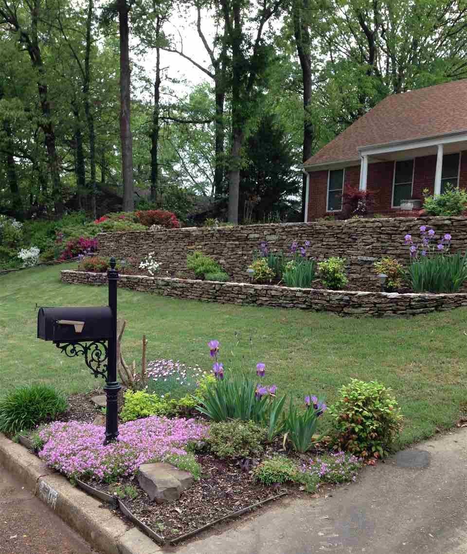 Another view of the front of the home showing the beautifully terraced front yard with stone wall.