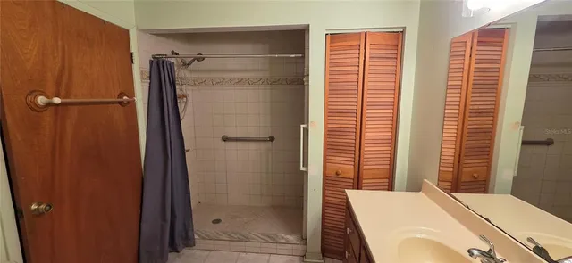 a bathroom with a shower sink and mirror