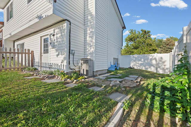 12152 Cinnamon Ridge Road Sandy, UT 84094 - Photo 31 of 34 Side yard with white siding, a white privacy fence, and a wooden picket fence