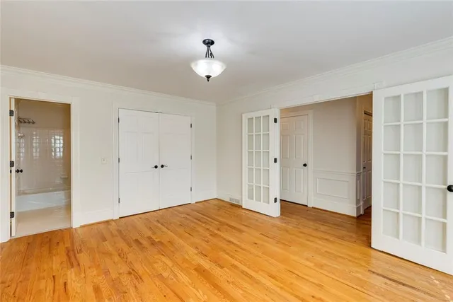 a big room with wooden floor and bathroom view