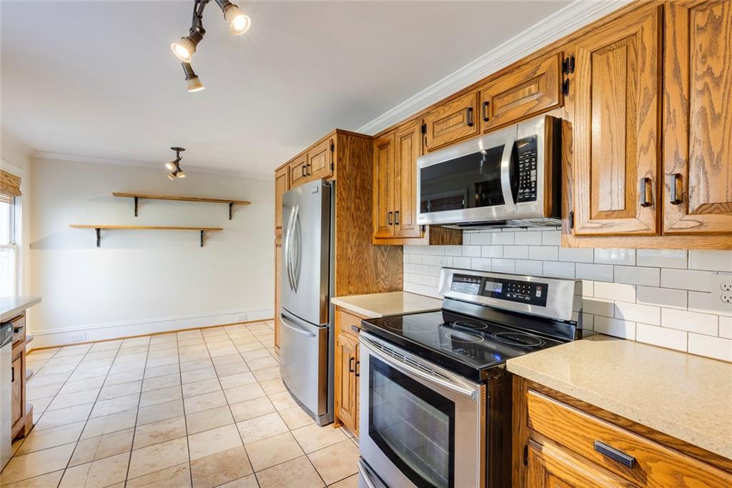 5377 Trentham Drive Dunwoody, GA 30338 - Photo 22 of 51 a kitchen with a stove a microwave and a refrigerator