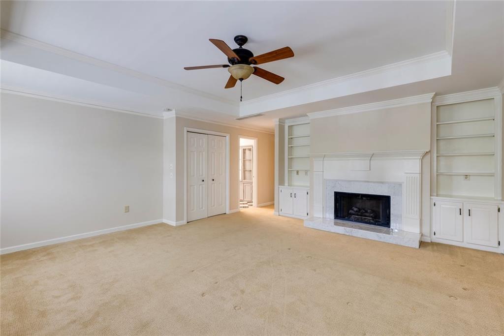 5377 Trentham Drive Dunwoody, GA 30338 - Photo 37 of 51 a view of empty room with a fireplace and a ceiling fan
