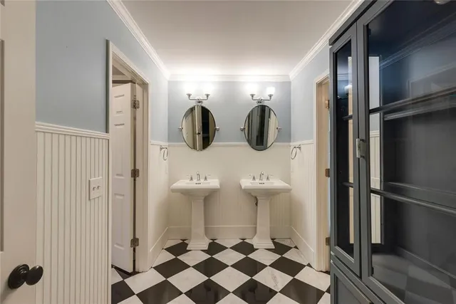 a white toilet sitting next to a white sink and vanity