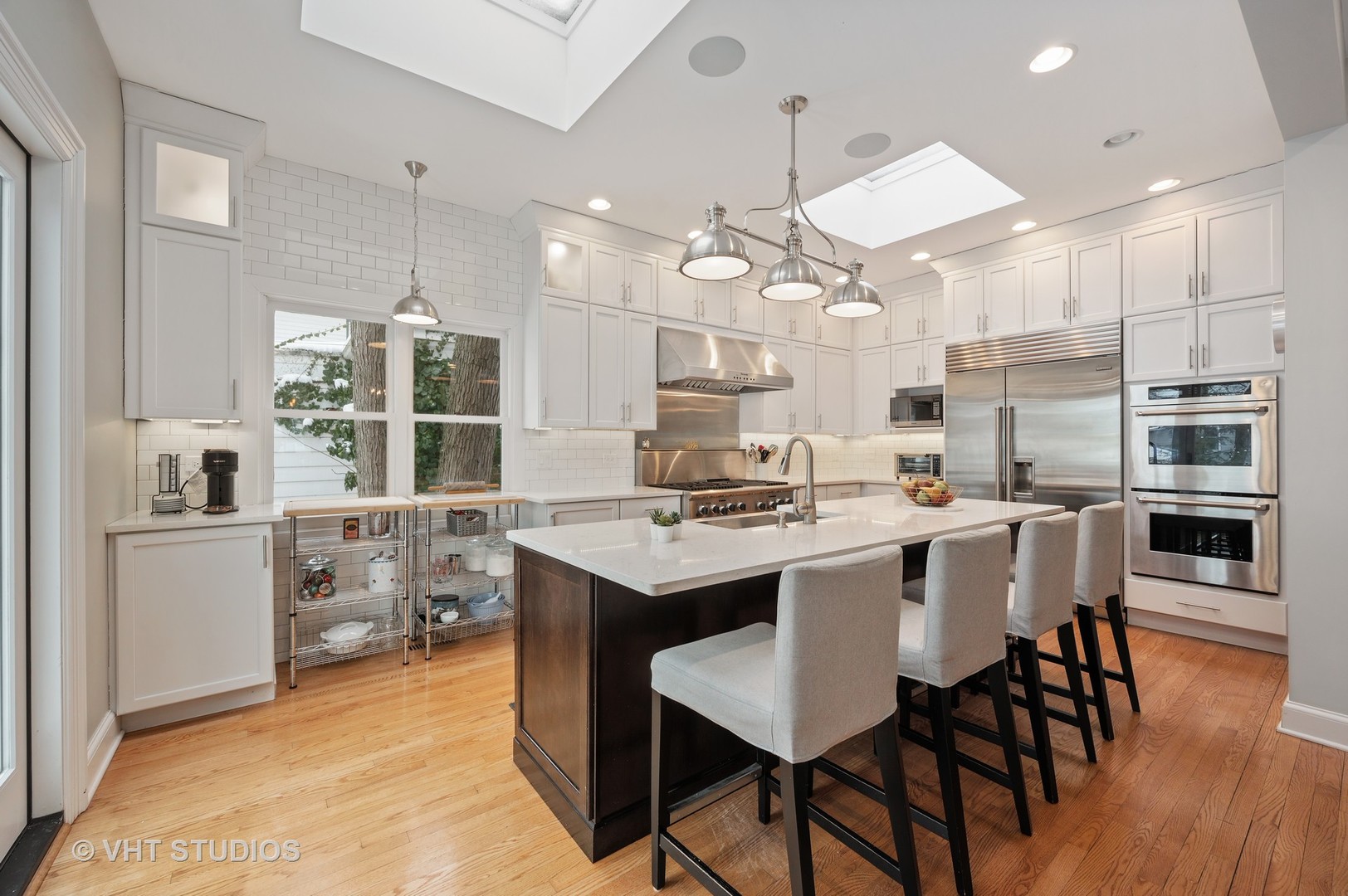 1031 Maple Avenue Evanston, IL 60202 - Photo 15 of 54 a kitchen with stainless steel appliances a table chairs stove and kitchen island
