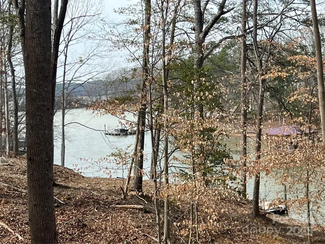 a view of swimming pool with lawn chairs and wooden fence