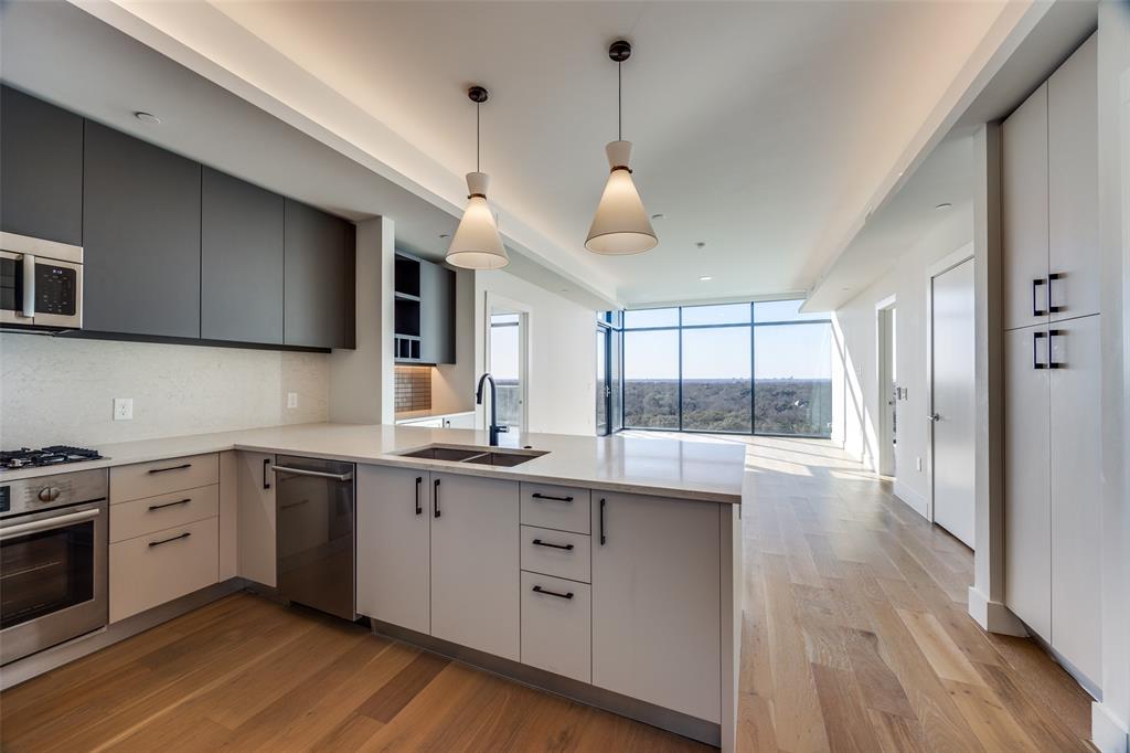 8119 Douglas Avenue, Unit 908 Dallas, TX 75225 - Photo 1 of 26 Kitchen with floor to ceiling windows, sink, kitchen peninsula, pendant lighting, and stainless steel appliances