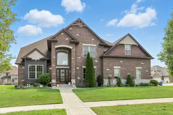 a front view of a house with a garden