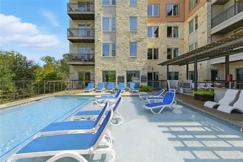 a view of a swimming pool with a lounge chairs in patio