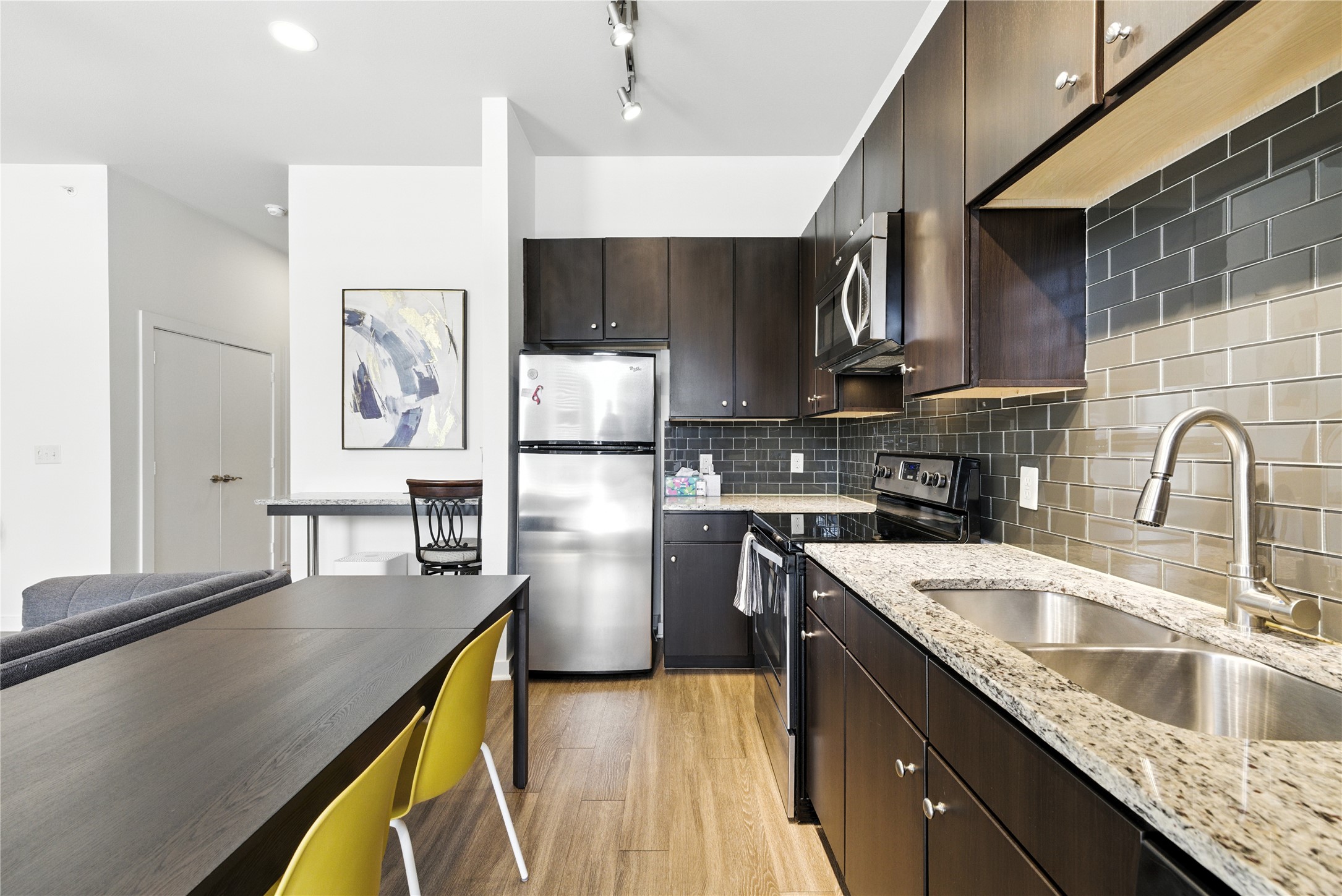1900 Barton Springs Road, Unit 2003 Austin, TX 78704 - Photo 7 of 20 a kitchen with kitchen island granite countertop a sink a counter space appliances and cabinets