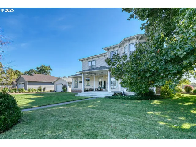 a view of a house with a big yard and large trees