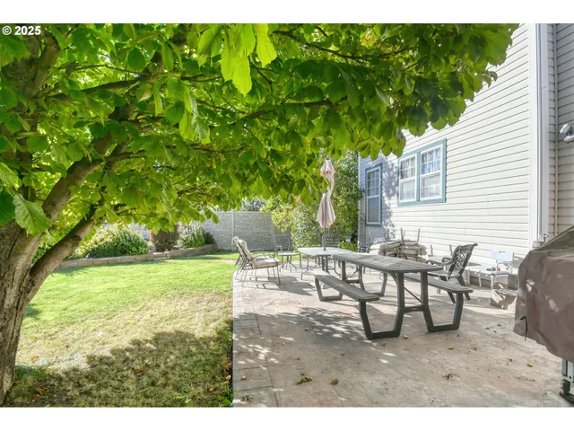 a backyard of a house with table and chairs