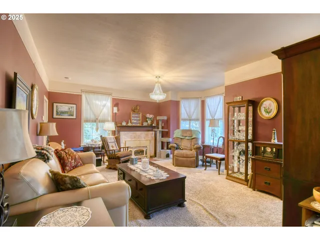 a living room with furniture kitchen view and a window