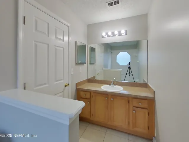 a bathroom with a sink a light fixture and a mirror