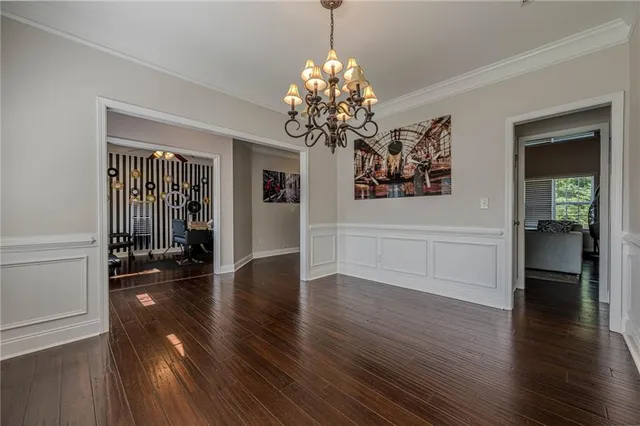 a view of a hallway with wooden floor and a chandelier