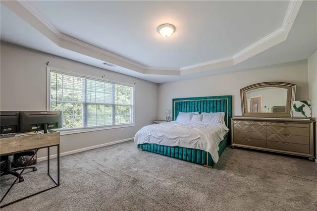 a spacious bedroom with a bed window and a table in it