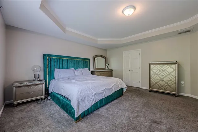 a bedroom with a large bed and a view of living room