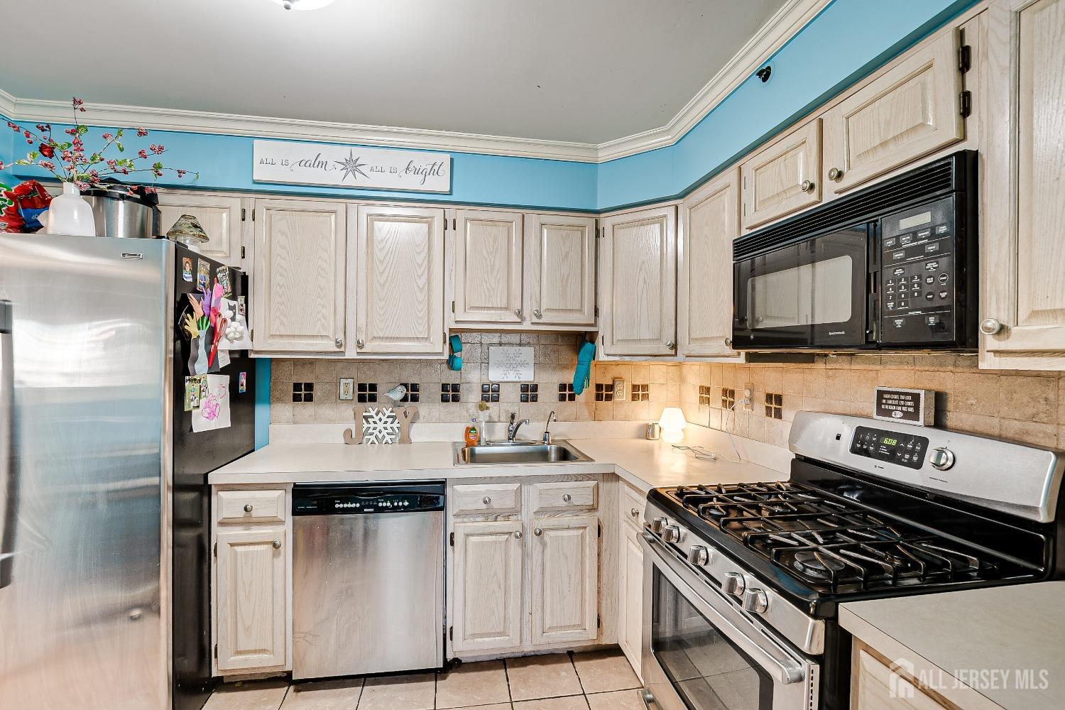 409 North Lafayette Road, Unit 409 Metuchen, NJ 08840 - Photo 12 of 24 a kitchen with stainless steel appliances a stove a sink cabinets and a window