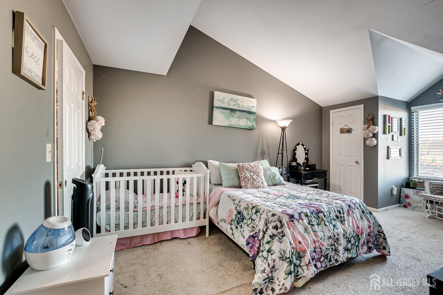 409 North Lafayette Road, Unit 409 Metuchen, NJ 08840 - Photo 16 of 24 a bedroom with a bed and a chandelier