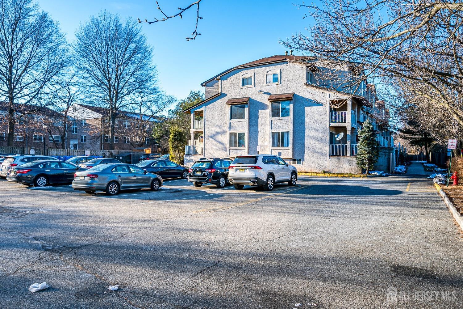 409 North Lafayette Road, Unit 409 Metuchen, NJ 08840 - Photo 2 of 24 a front view of a building with lot of cars and trees