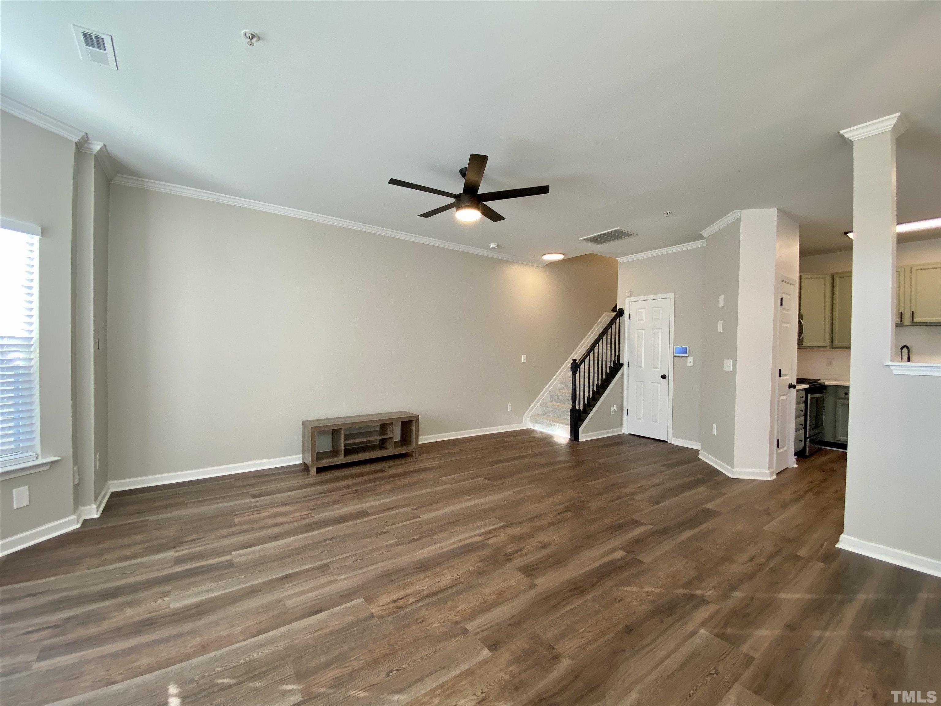 2225 Raven Road, Unit 108 Raleigh, NC 27614 - Photo 4 of 26 a view of an empty room with wooden floor and a ceiling fan