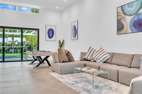 a living room with furniture and a floor to ceiling window