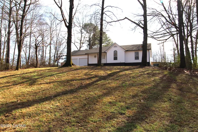 a view of a large house with a big yard and large tree