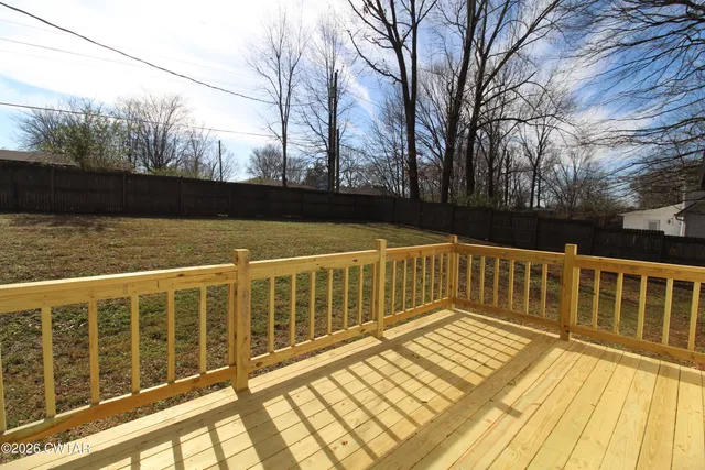 a view of a balcony with wooden floor and fence