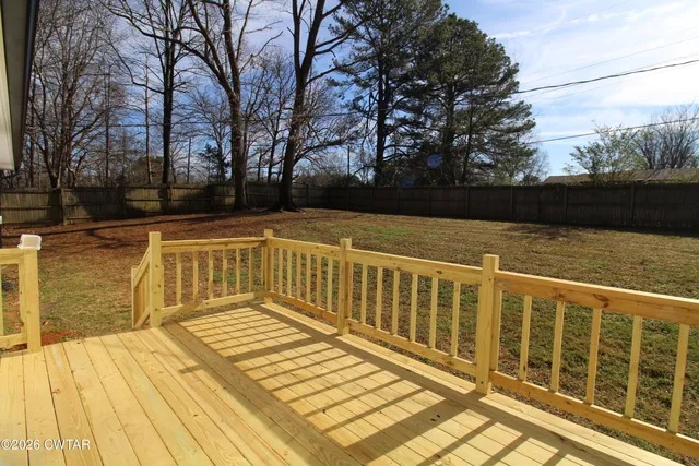 a view of balcony with wooden floor and fence