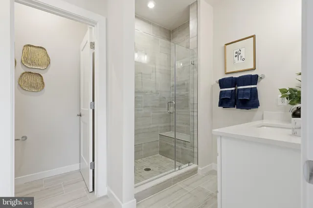 a bathroom with a shower a mirror and a sink