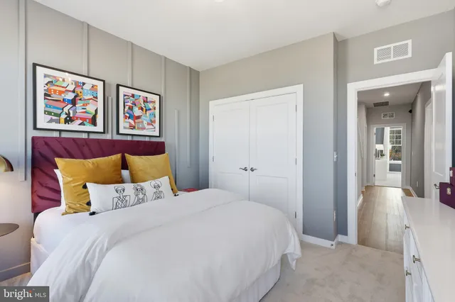 a bedroom with a bed and painting on the wall