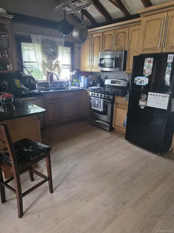 a kitchen with stainless steel appliances granite countertop a stove a sink and a refrigerator