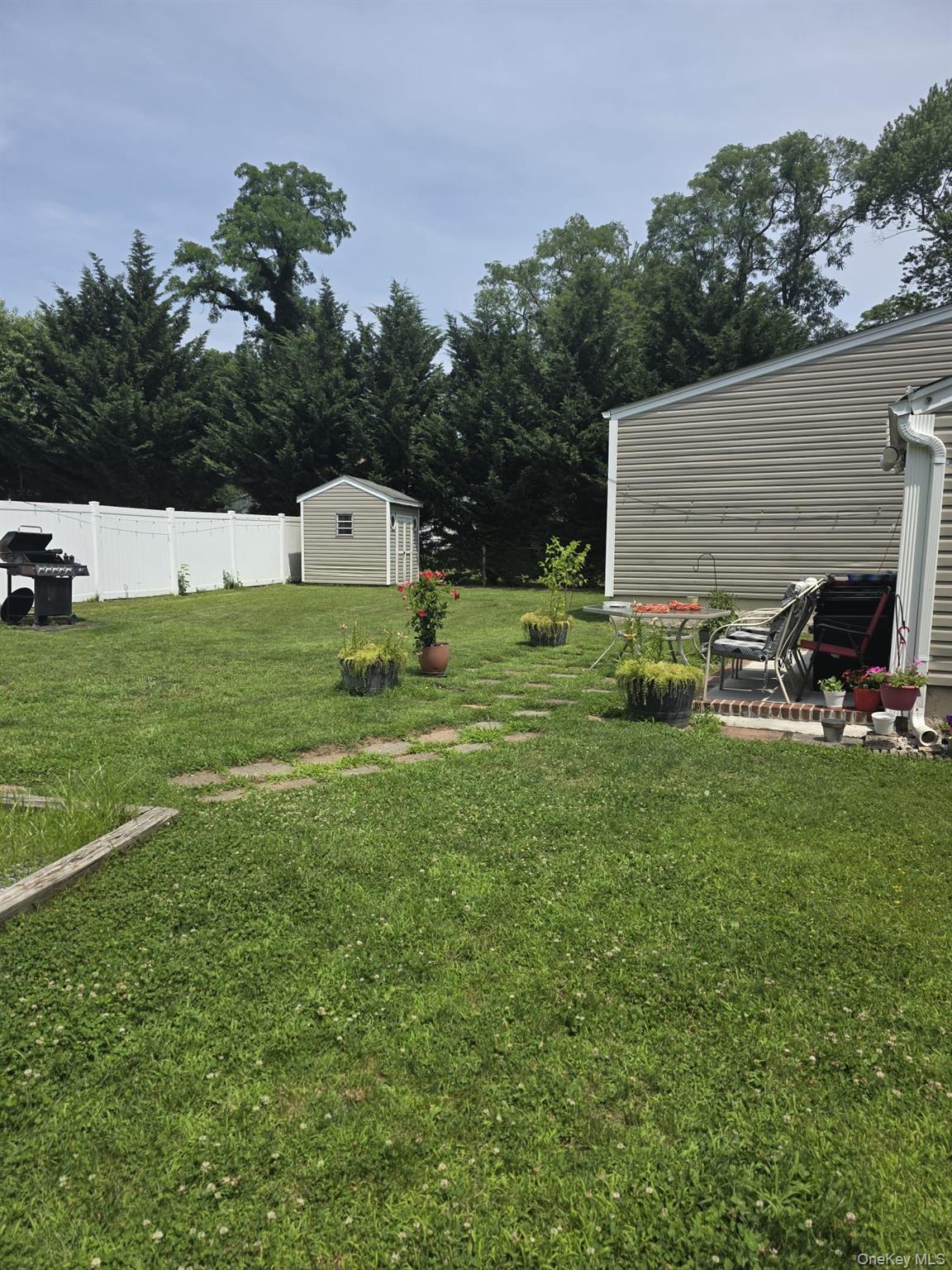 23 Seaman Neck Road Dix Hills, NY 11746 - Photo 10 of 12 a backyard of a house with table and chairs