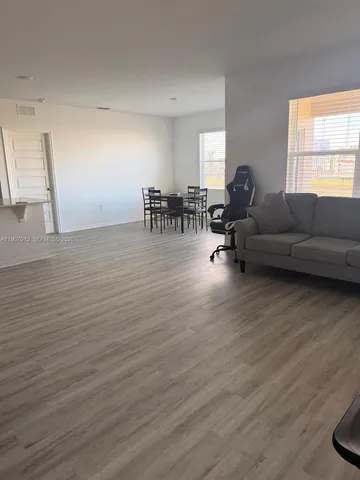 a living room with furniture and a wooden floor