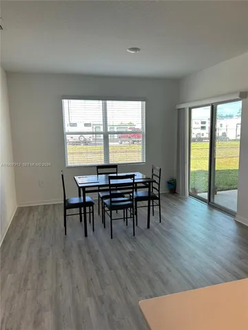 a dining room with furniture and wooden floor