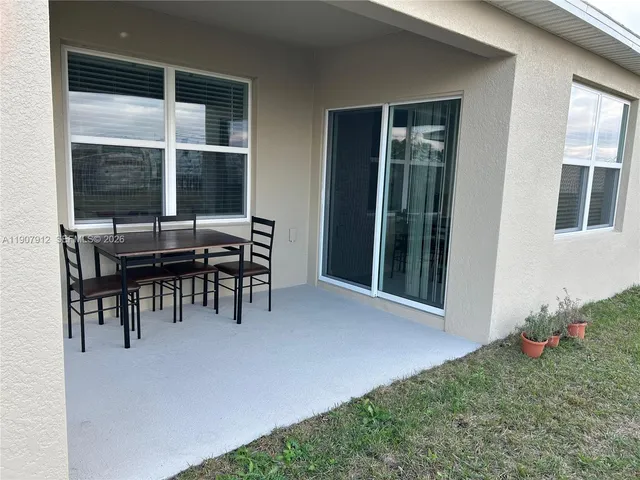 a view of an chairs and table in patio next to a window