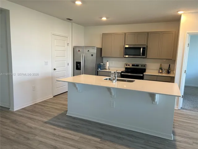 a kitchen with stainless steel appliances a refrigerator sink and microwave